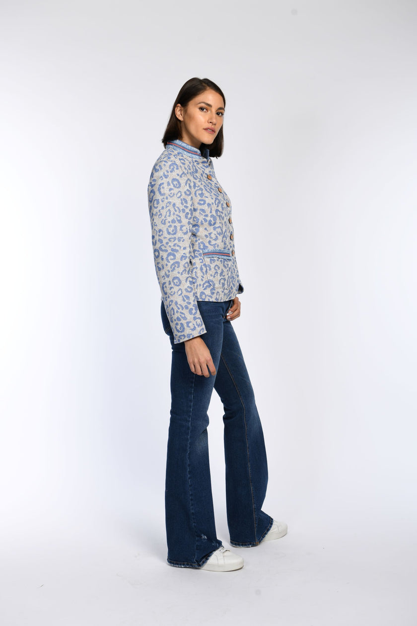Seitenansicht: Janker mit blauem Leopardenprint auf hellem Grund, Stehkragen sowie aufgesetzten Taschen mit Fransenband.