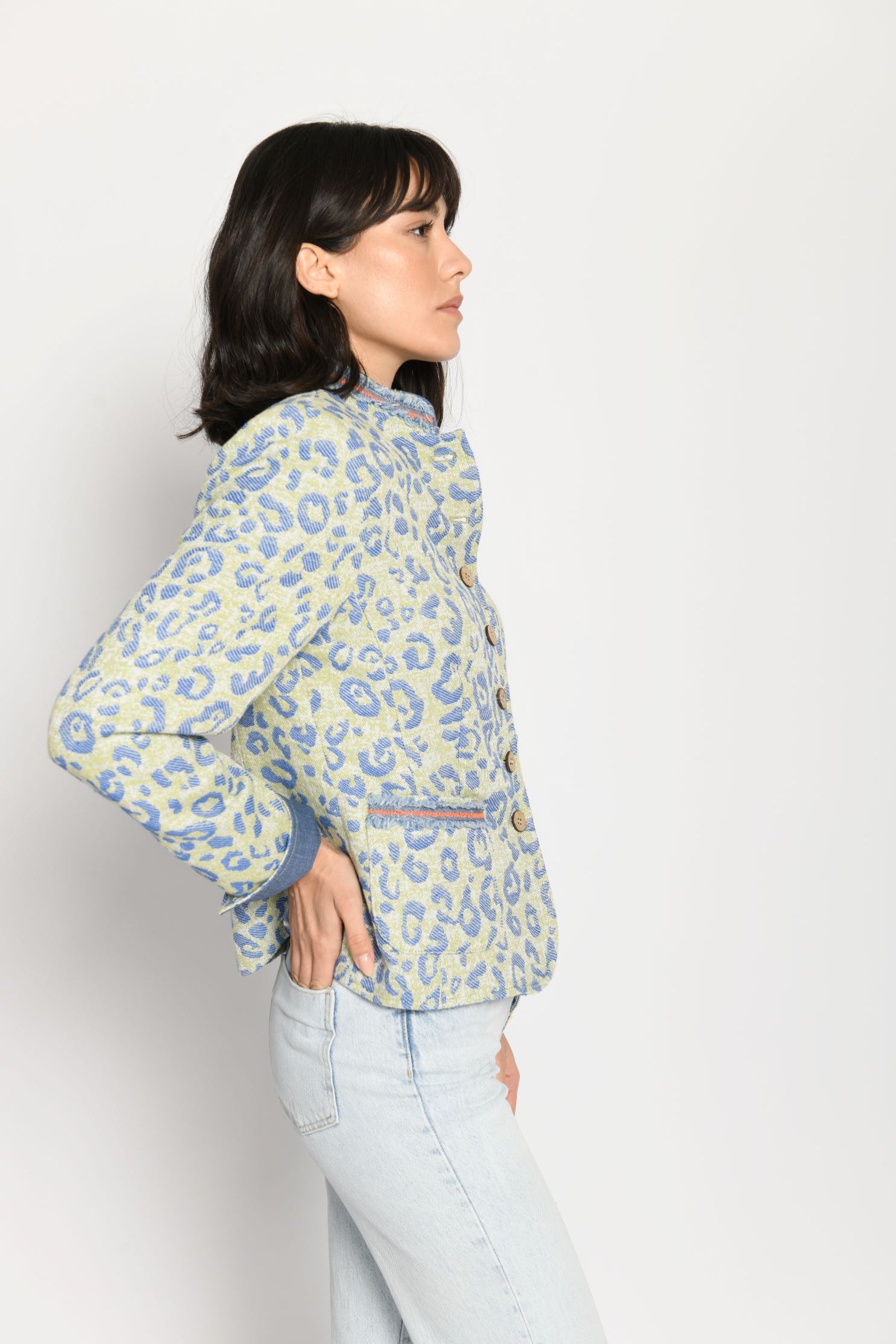 Seitenansicht des blauen Leopardenprints auf grünem Janker und aufgesetzten Taschen mit Fransenband.