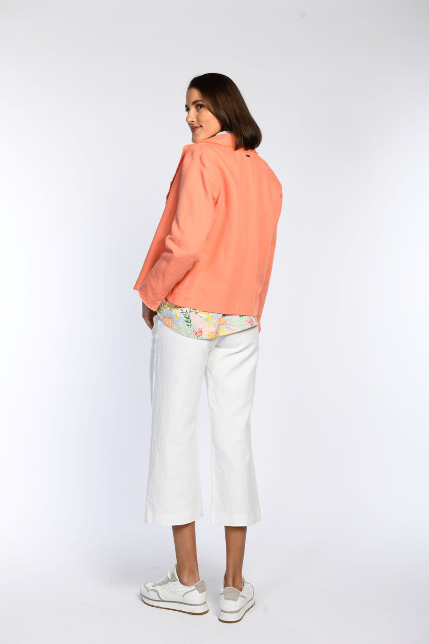 Rückenansicht: Model in kastiger, orangefarbener Jacke mit Reverskragen.