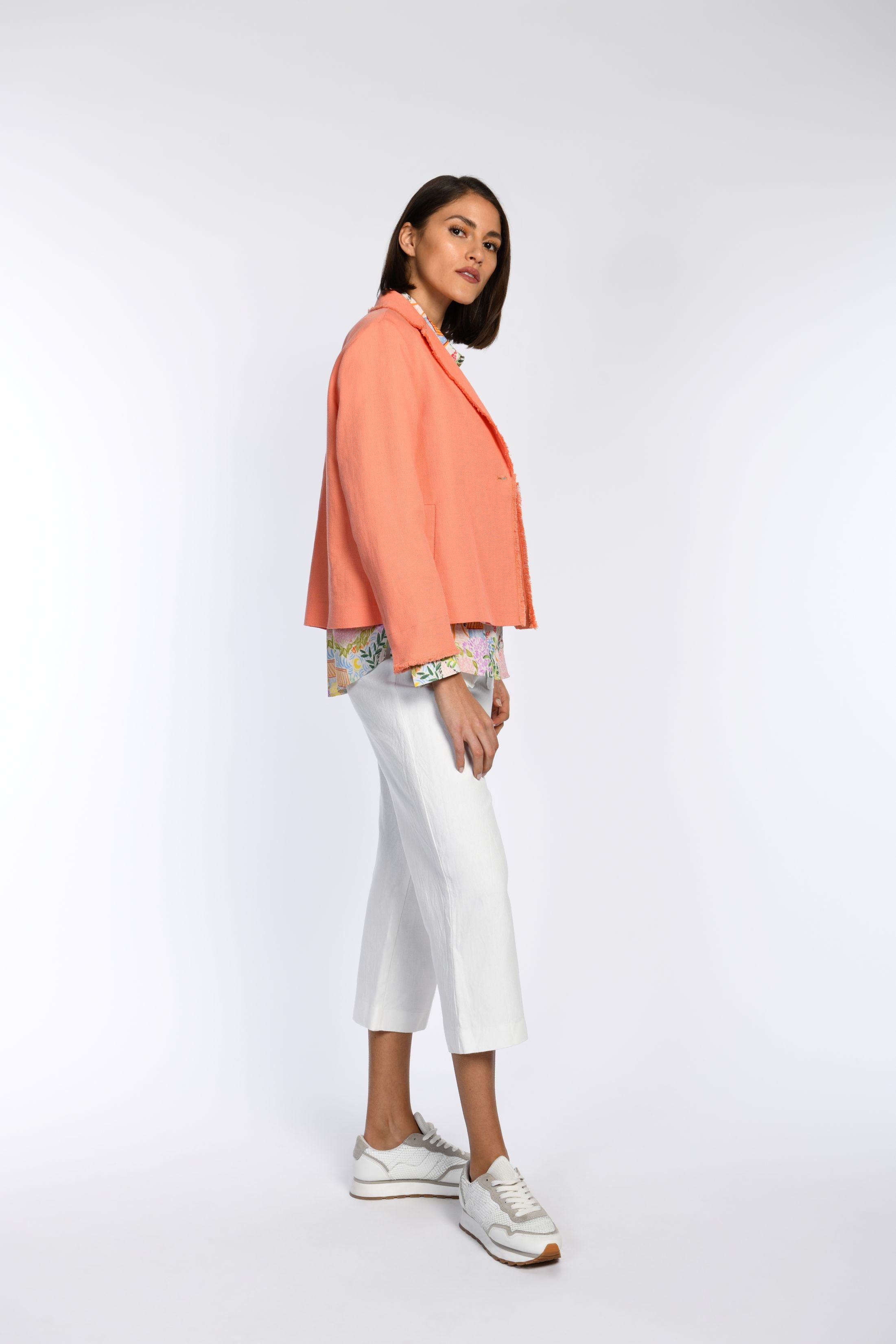 Model in orangefarbener Kastenjacke mit Reverskragen.