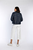 Das Model zeigt die Rückenansicht einer gerade geschnittenen Kastenjacke im Denim-Look.