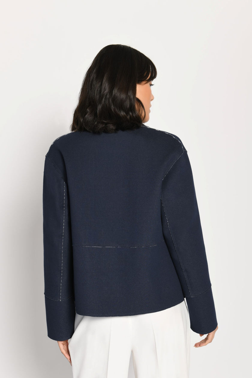 Model trägt langärmelige, dunkelblaue Kastenjacke aus Scuba – Rückansicht