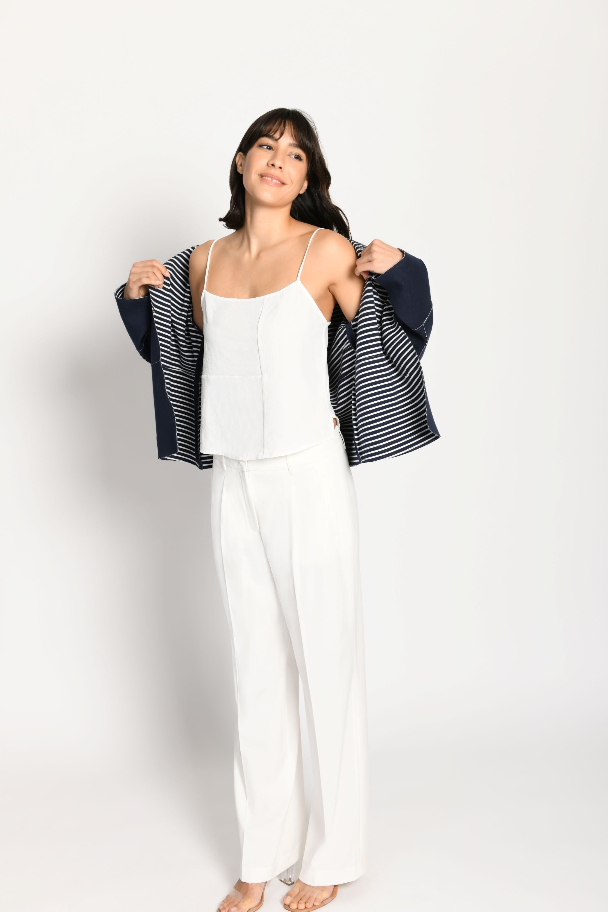 Model trägt dunkelblaue Kastenjacke aus Scuba mit weiß gestreifter Innenseite als Kontrast, offen getragen - Vorderansicht.