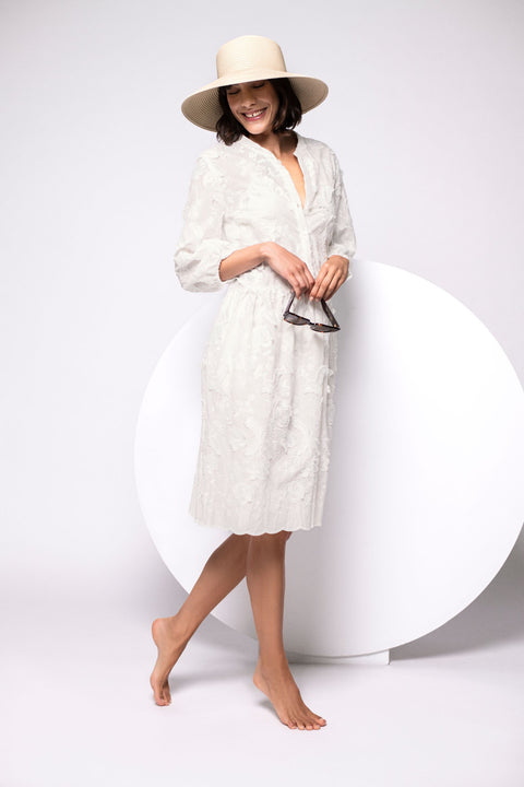 Locker fallendes Tunikakleid am Model mit dekorativer Blütenstickerei, 3/4-Ärmeln und Rundhalsausschnitt.