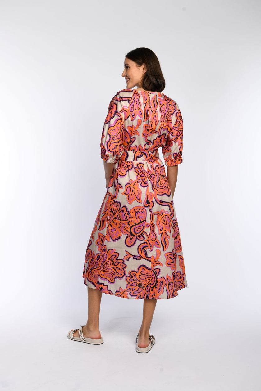 Model trägt Sommerkleid aus 100 % Baumwolle mit floralem Druck in Pink und Orange - Rückansicht.
