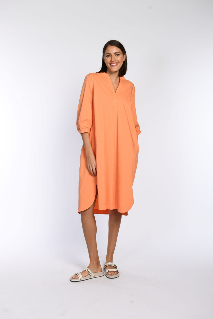 Oranges, leichtes, knielanges Sommerkleid in A-Linie mit 3/4-Ärmeln - lässig kombiniert mit leichten offenen Schuhen.
