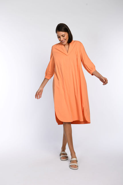 Orangfarbenes, leichtes Sommerkleid in Vorderansicht mit sichtbarem, seitlichen Schlitz am Saum. 