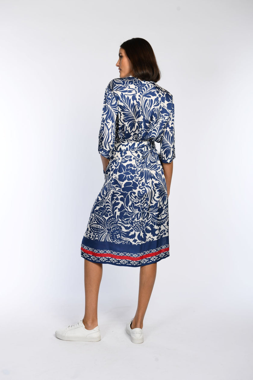 Knielanges, locker geschnittenes Baumwollkleid mit blauem Blumendruck, Halbarm und V-Ausschnitt - Rückansicht.