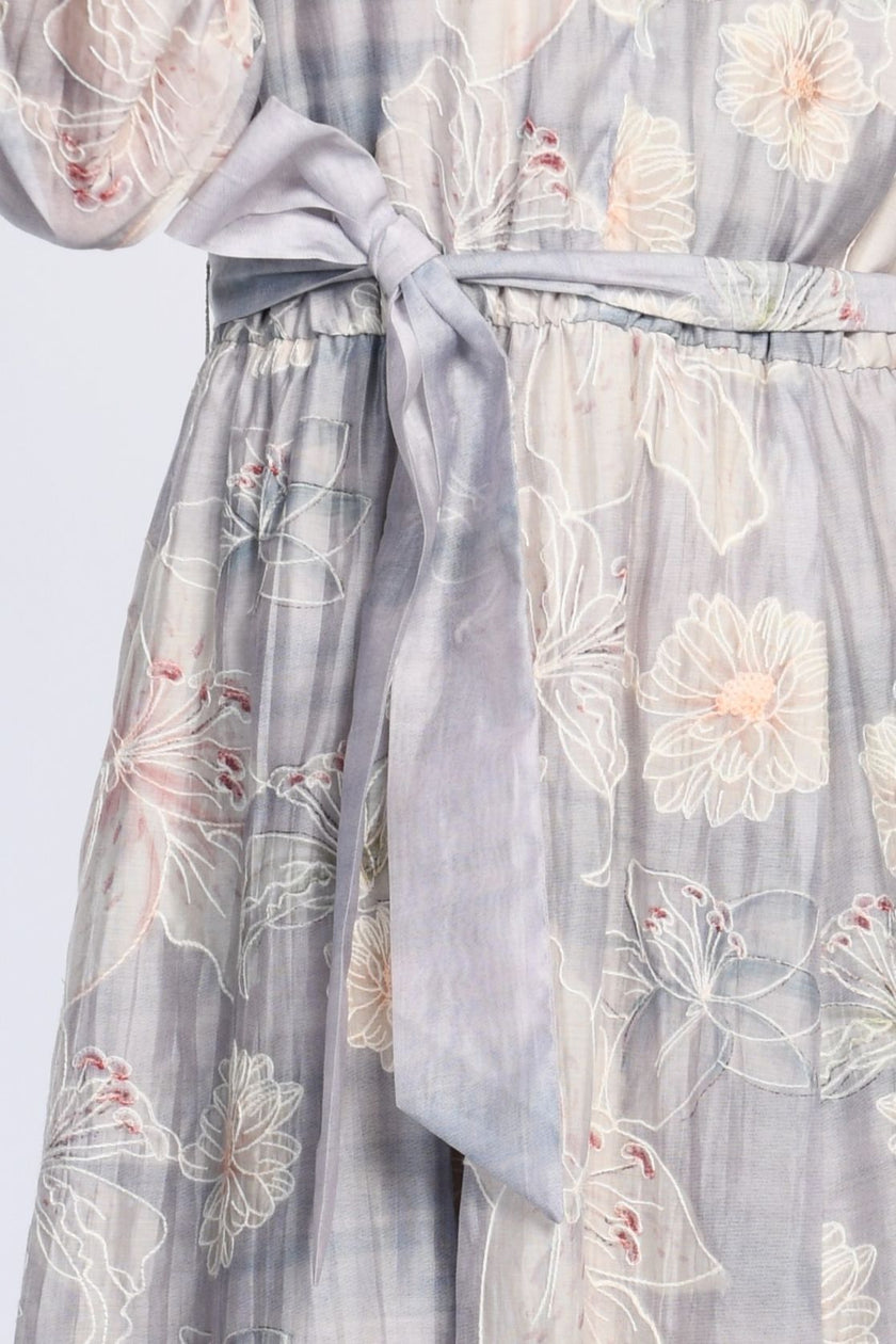 Detailansicht des bedruckten Maxikleids mit zartem Pastellprint, langärmelig, Fokus auf Bindegürtel in der Taille.