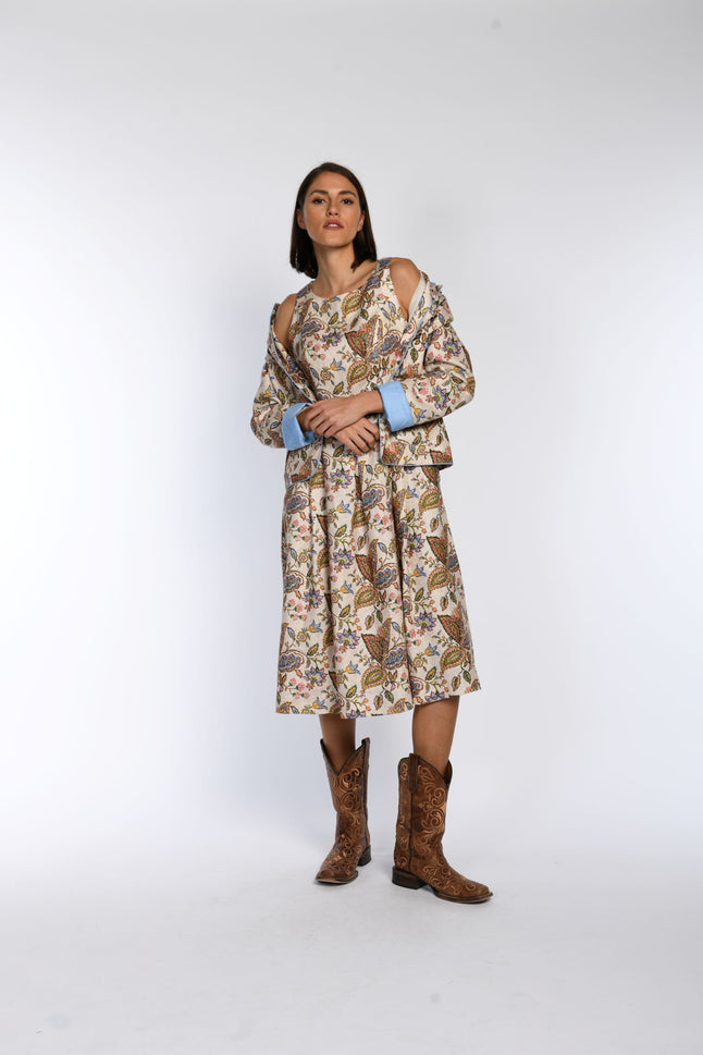 Figurbetontes, bedrucktes, ärmelloses Trachtenkleid in Kombination mit passendem Janker und coolen Cowboystiefeln.