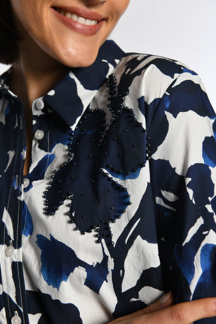 Gemustertes Hemdblusenkleid mit schwarzer Perlenstickerei auf der linken Vorderseite.