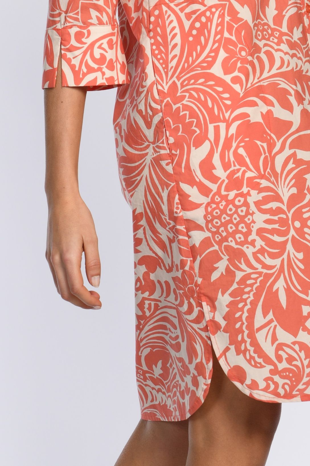 Foto zeigt orangefarbenes, weiß gemustertes Hemdblusenkleid mit Seitenschlitz und 3/4-Ärmel inklusive Ärmelschlitz.