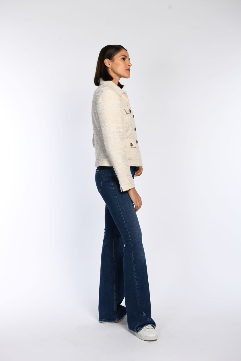 Cremefarbene, langärmelige Jacke in Seitenansicht mit sichtbarem Ärmelschlitz, kombiniert zur blauen Jeans.