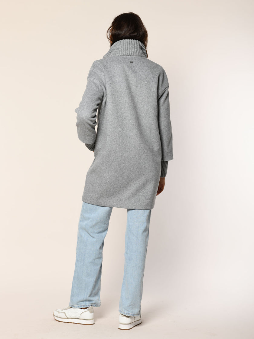 Model trägt Mantel mit Stehkragen aus Strick in der Farbe grau - Rückansicht.