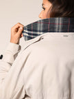 Model trägt klassischen Baumwoll Trenchcoat in der Farbe Stein - Detailansicht.