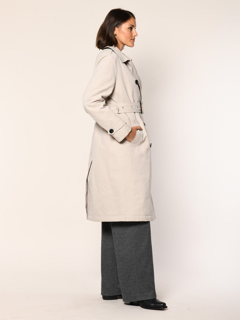 Model trägt klassischen Baumwoll Trenchcoat in der Farbe Stein - Seitenansicht.