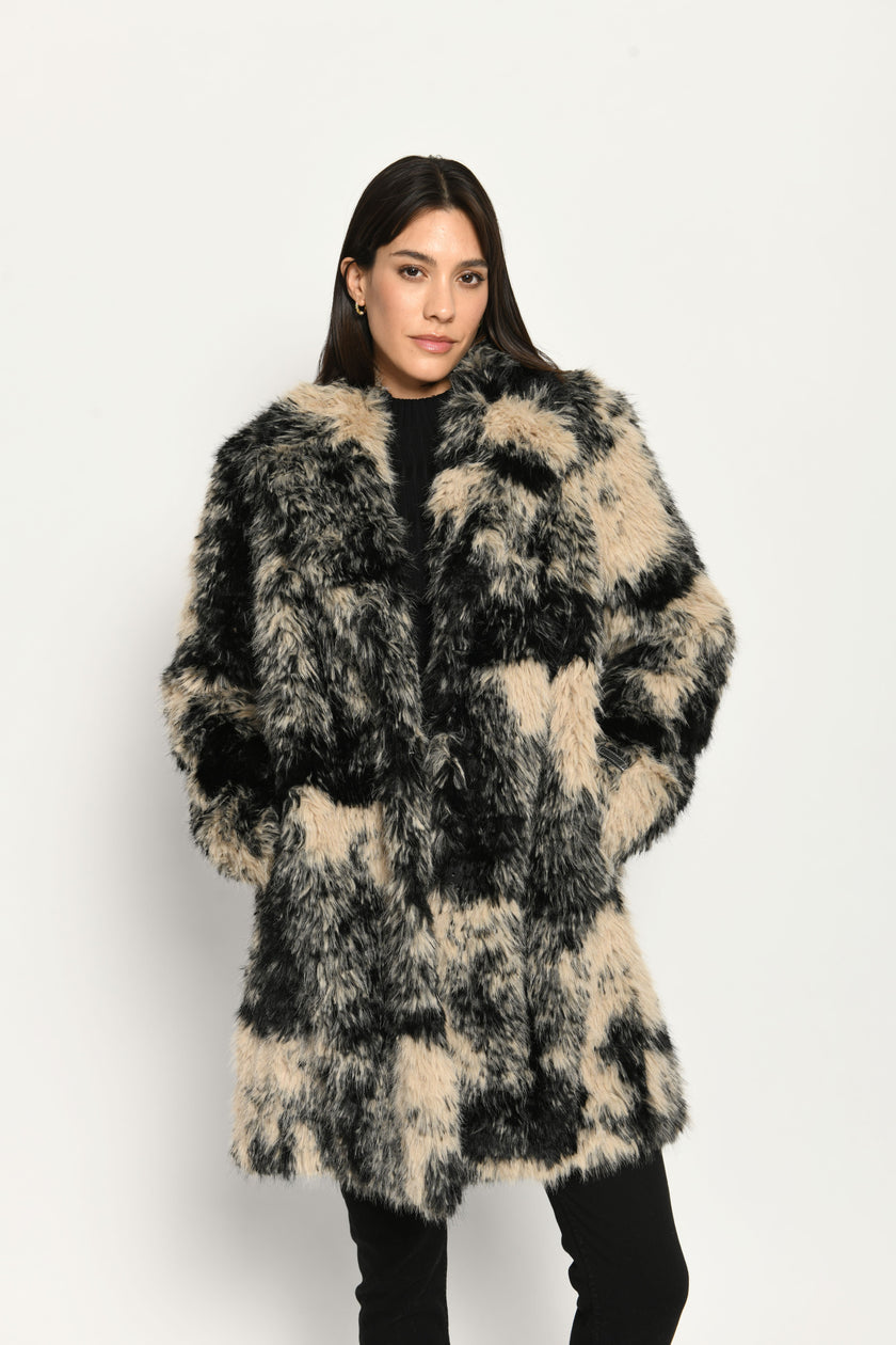 Damenmantel aus langhaarigem schwarz-beigen Webpelz für den Winter – Vorderansicht, geschlossen getragen