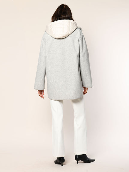 Model trägt einen oversized Parka mit herausnehmbaren Westeneinsatz in der Farbe Kiesel - Rückansicht.