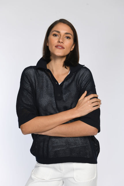 Model trägt blaues Poloshirt aus Ajour-Strick mit Umlegekragen und verkürzter Knopfleiste.
