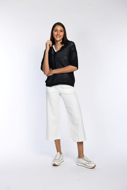 Locker geschnittenes Poloshirt mit Umlegekragen aus Ajour-Strick, am Model getragen. 