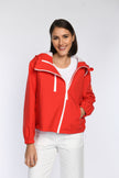 Rote sportliche Regenjacke, geschlossen, mit Taschen und verstellbarem Tunnelzug am Saum.