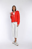 Model trägt eine rote sportive Regenjacke mit Kapuze.