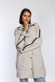 Model trägt Regenparka in der Farbe beige.