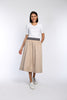 Model trägt beigen Rock in A-Linie mit gestreiftem Gummibund und schrägen Eingriffstaschen.