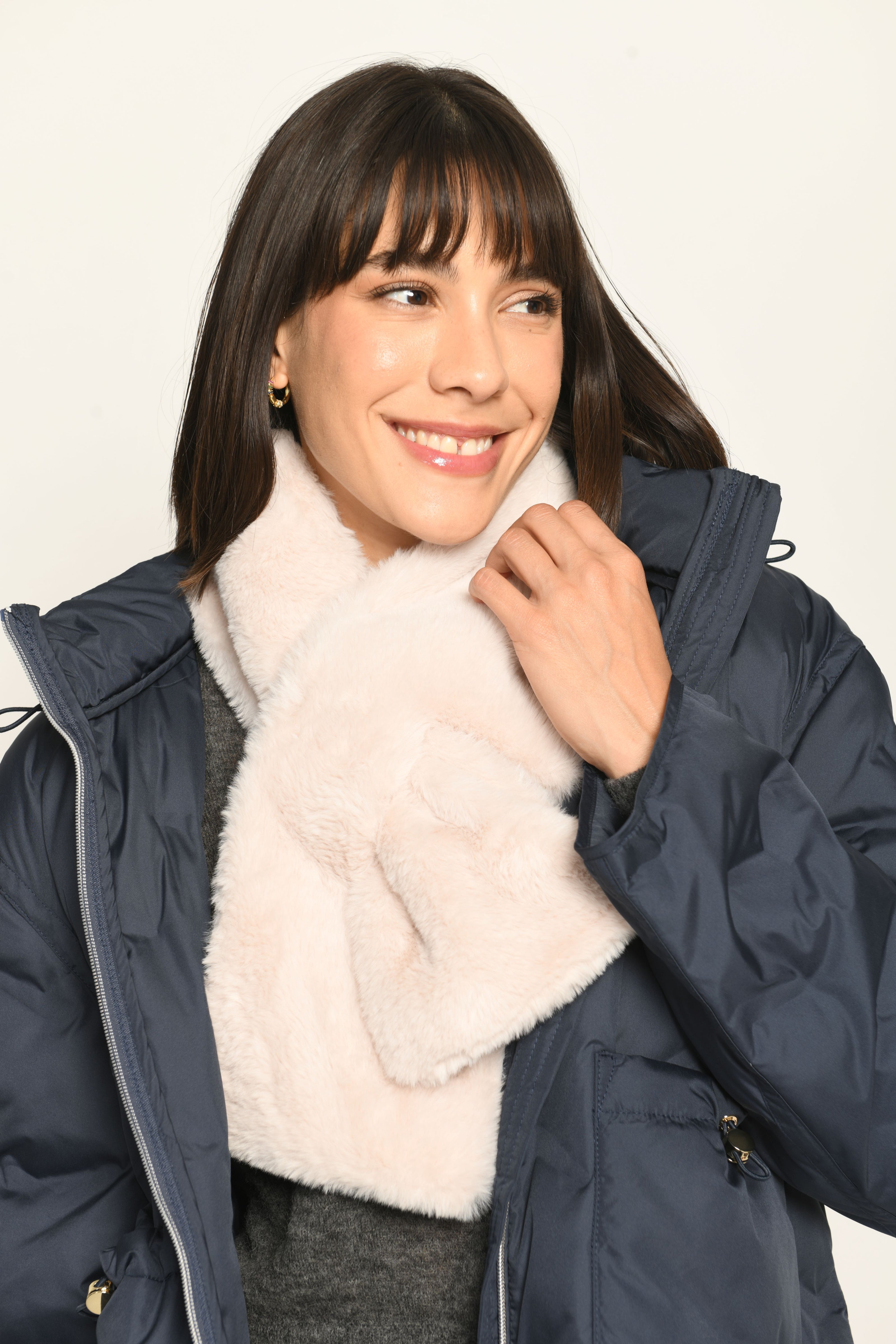 Model trägt kuschelig weichen Webpelzschal in der Farbe weiß, passend zu unserer blauen Steppjacke – Vorderansicht