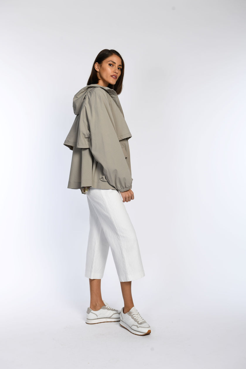 Seitenansicht einer dünnen Sommerjacke in Taupe mit Kapuze und elastischen Bündchen an den Ärmelabschlüssen.