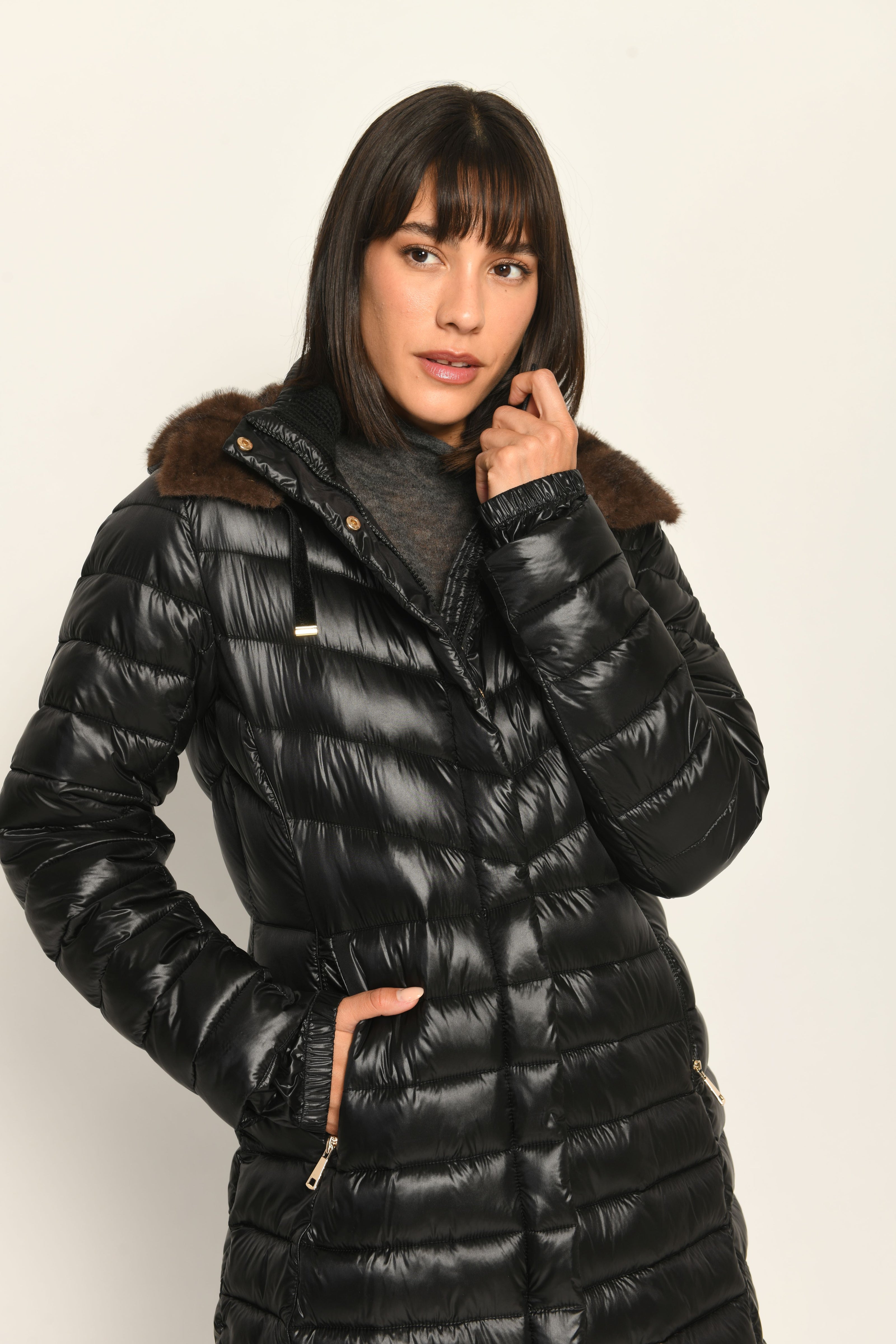 Taillierter schwarzer Steppmantel mit abnehmbarer Kapuze, welche mit braunem Webpelz gefüttert ist – Frontansicht