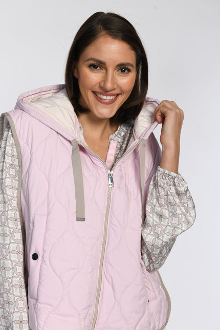 Nahaufnahme eines Models in einer rosafarbenen Steppweste mit Kapuze.