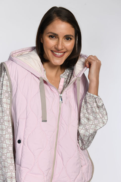 Nahaufnahme eines Models in einer rosafarbenen Steppweste mit Kapuze.