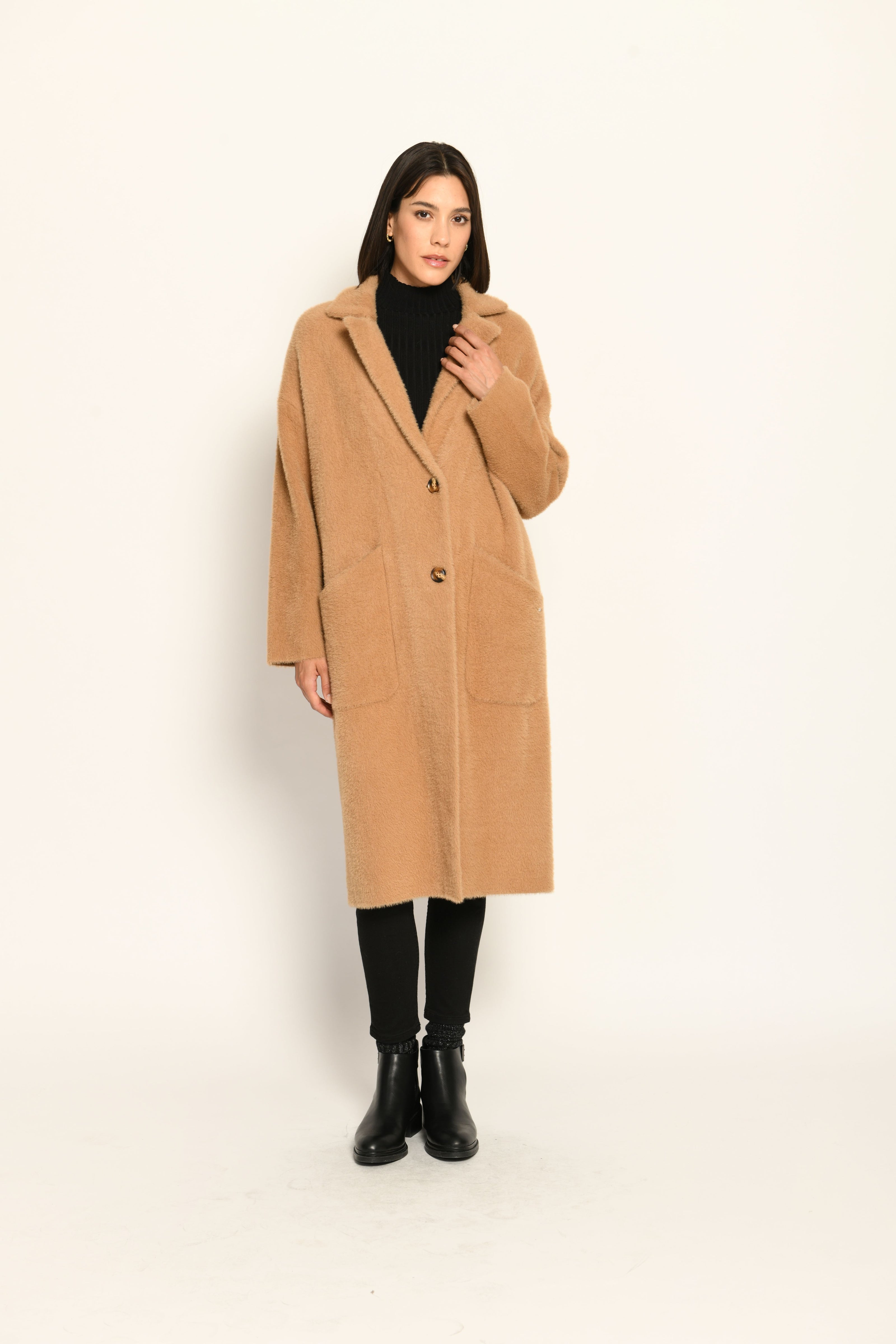 Model trägt knielangen braunen Strickmantel für Damen lässig kombiniert zu schwarzer Jeans – Vorderansicht