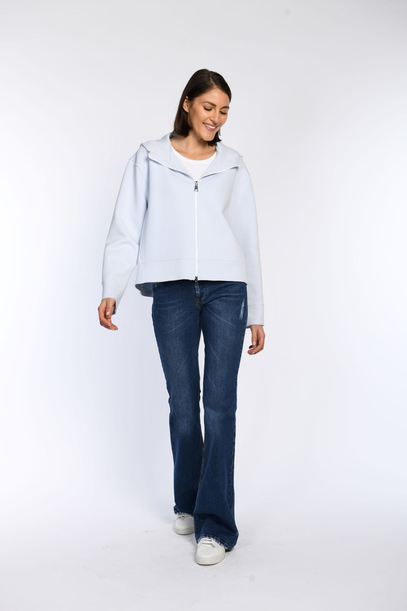 Vorderansicht eines Models in einer hellblauen Sweatjacke mit langen Ärmeln und einem Zwei-Wege-Reißverschluss.