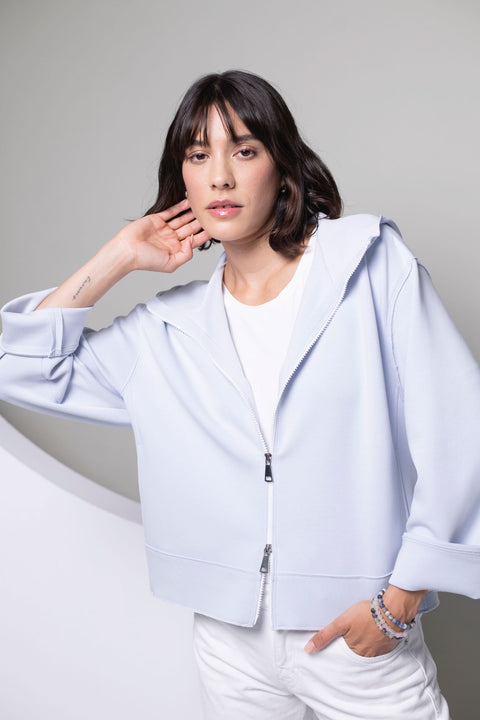 Detailansicht einer blauen Sweatjacke mit Fokus auf den Zwei-Wege-Reißverschluss.