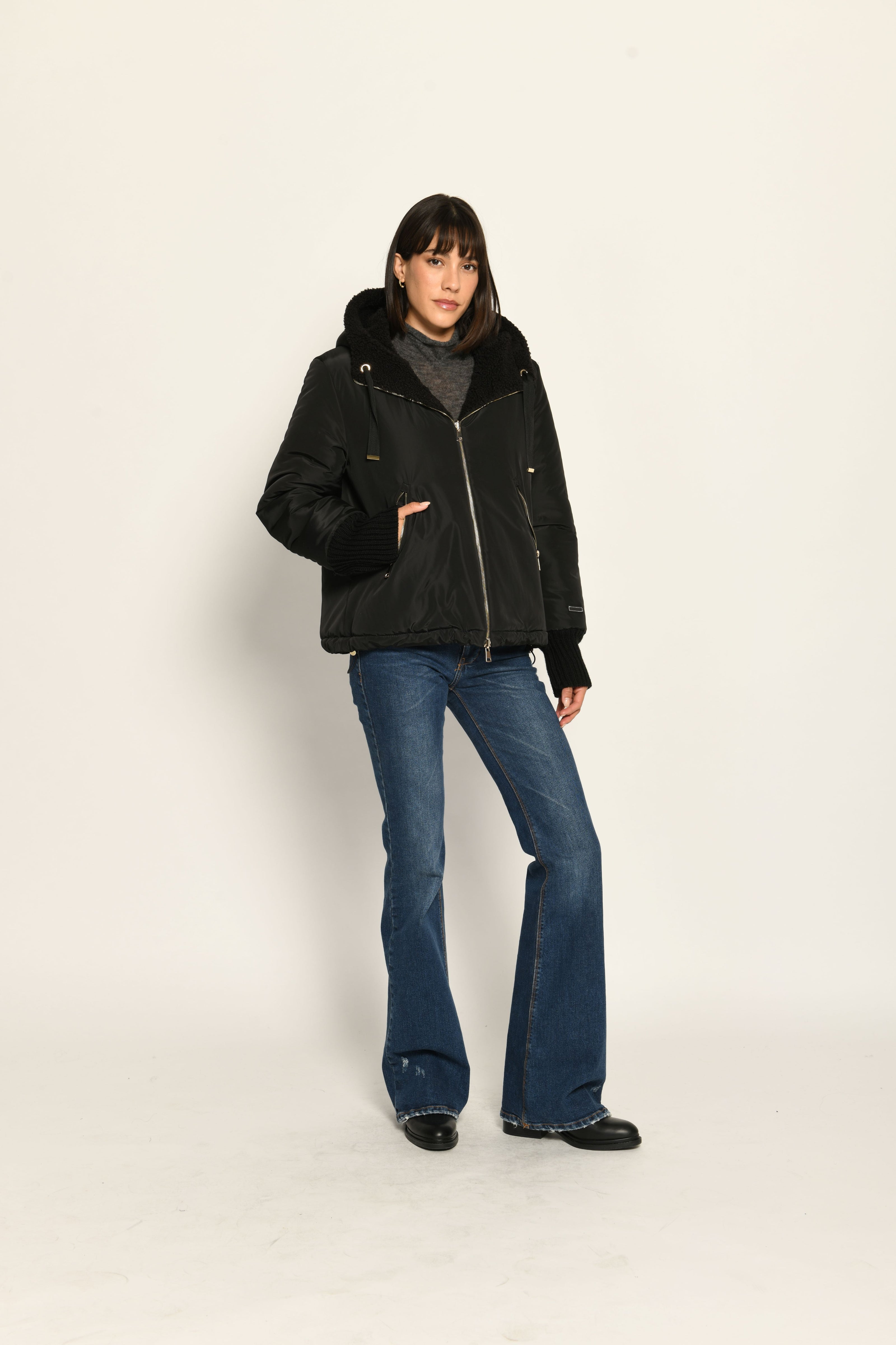 Model trägt schwarze gefütterte Wendejacke aus wärmendem Teddy-Webpelz mit Kapuze – Nylon-Außenseite