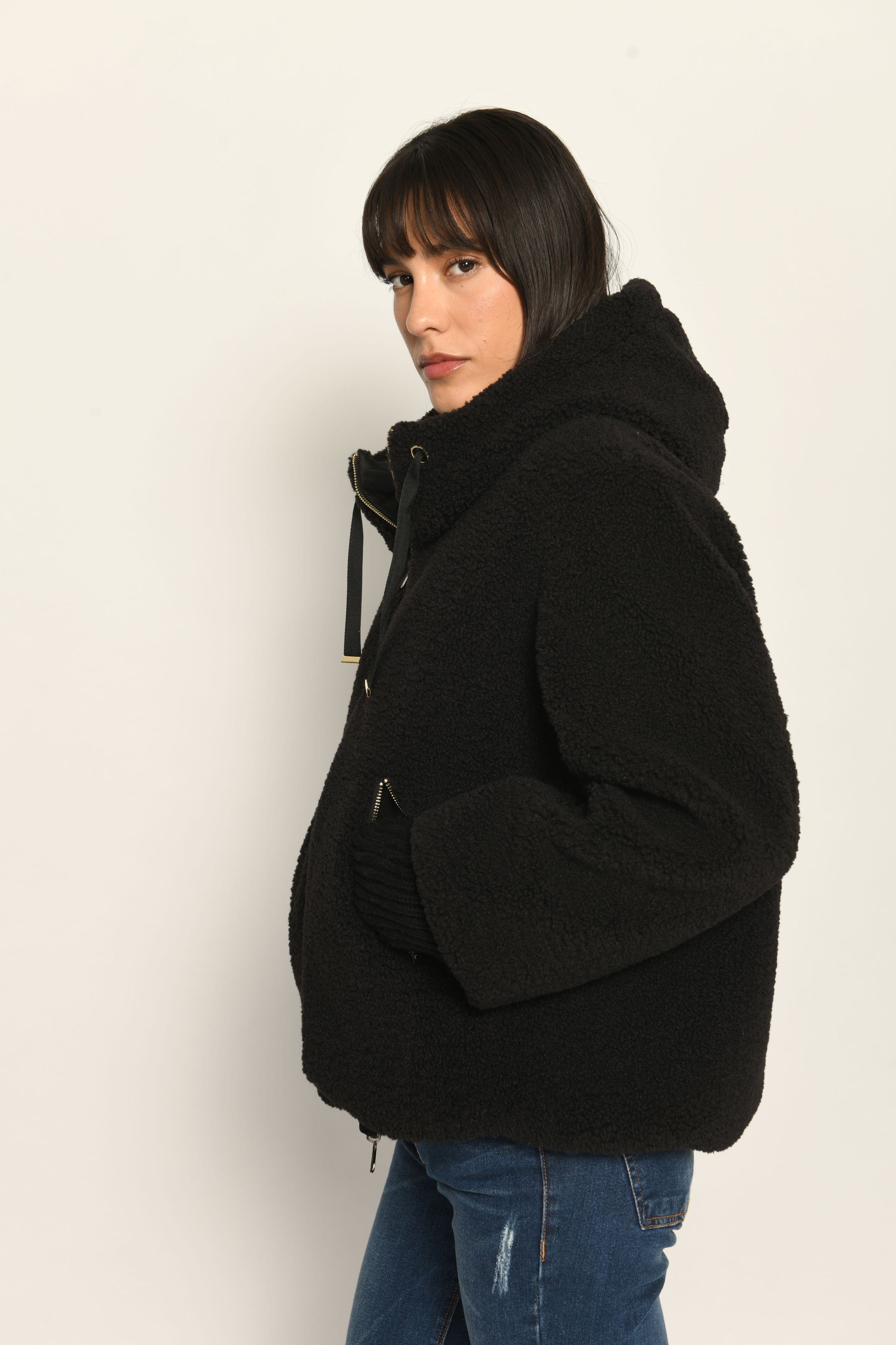 Model trägt schwarze gefütterte Wendejacke aus wärmendem Teddy-Webpelz mit Kapuze – Nahaufnahme Teddy-Außenseite