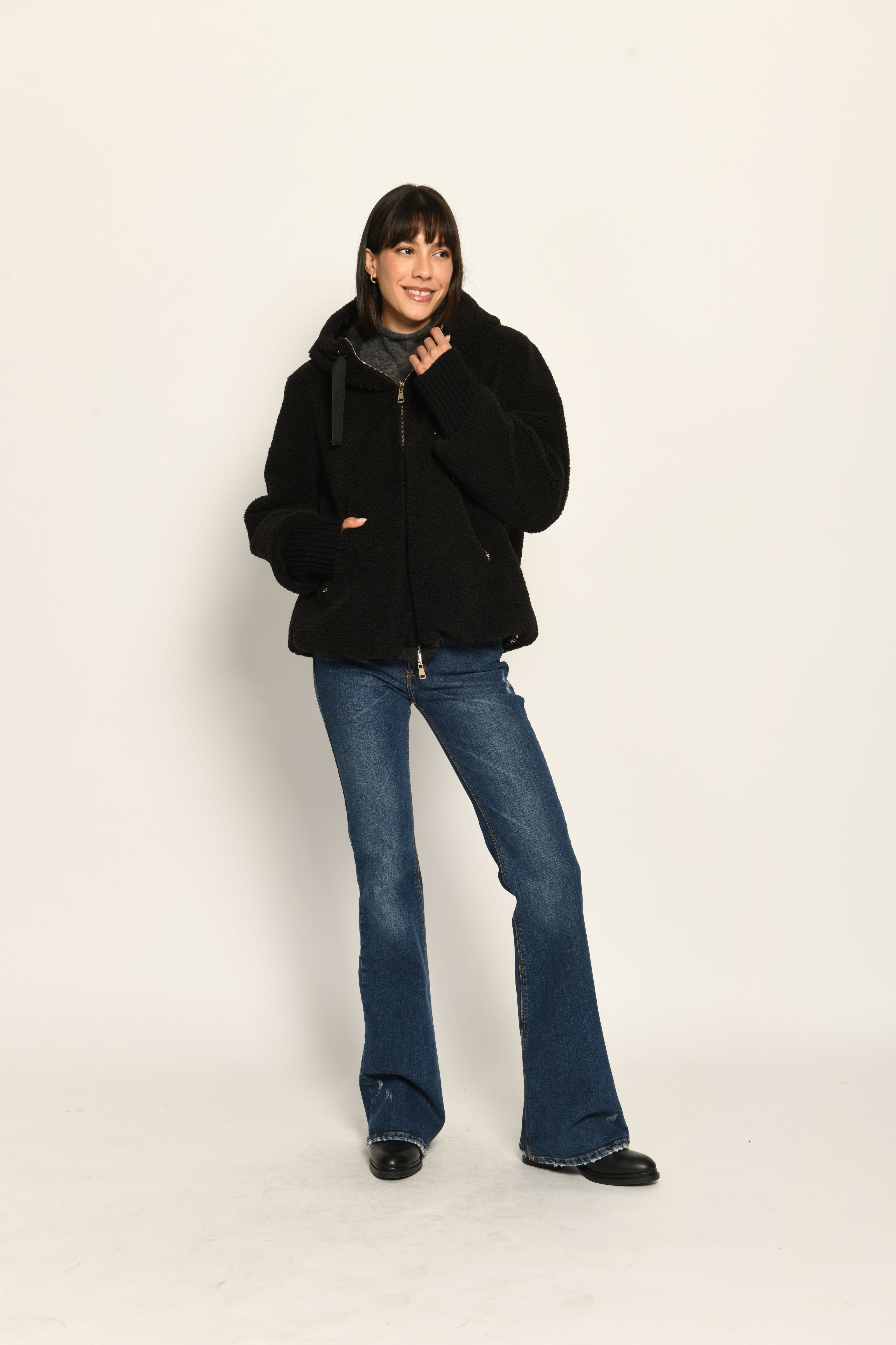 Model trägt schwarze gefütterte Wendejacke aus wärmendem Teddy-Webpelz mit Kapuze – Teddy-Vorderseite