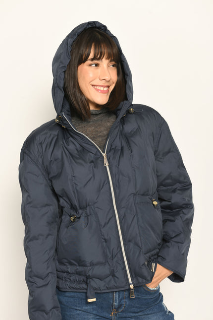 Model trägt sportive dunkelblaue Steppjacke für Damen mit Kapuze zu dunkelblauer Jeans – Detailaufnahme von Front