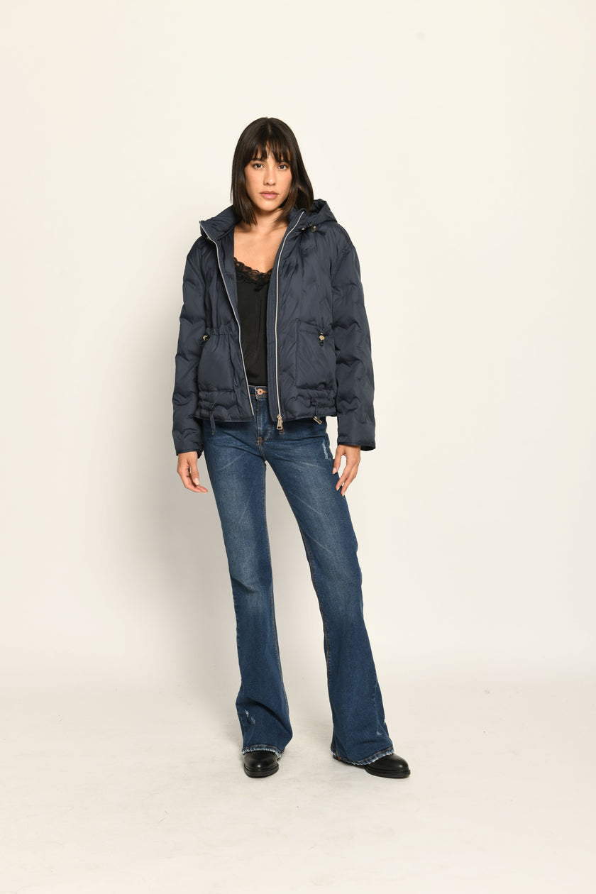 Offen getragene sportive dunkelblaue Steppjacke für Damen mit Kapuze zu dunkelblauer Jeans – Vorderansicht