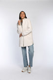 Model trägt Blouson zum Wenden in der Farbe Beige, kombiniert zu Jeans und Sneakern.