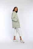 Model trägt Blouson zum wenden in der Farbe Mintgrün in Kombination mit einer weißen Jeans. 