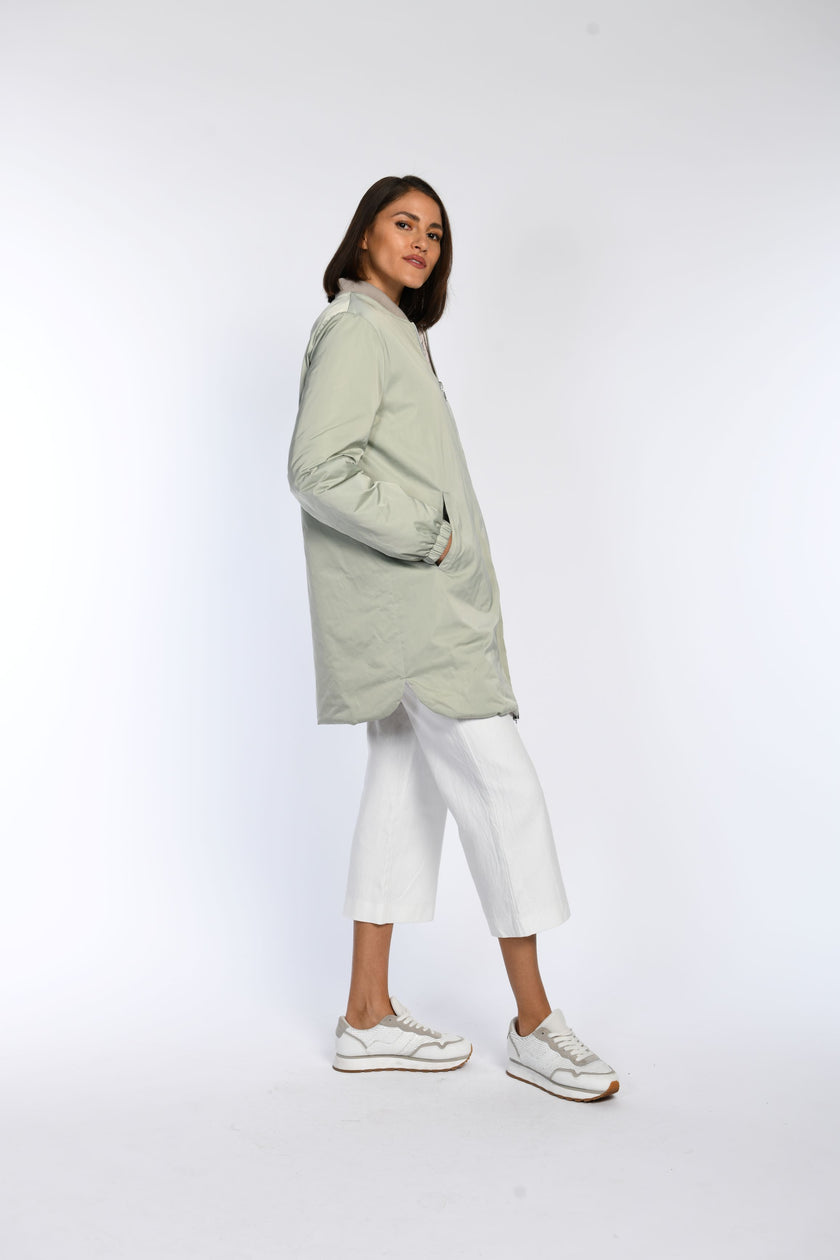 Model trägt Blouson zum wenden in der Farbe Mintgrün in Kombination mit einer weißen Jeans. 