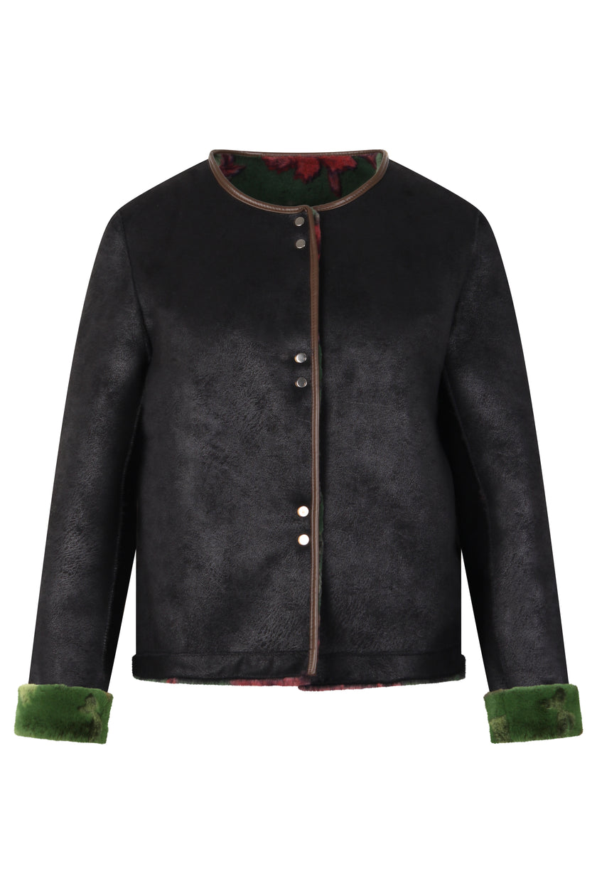 Wendejacke in Schwarz aus Velours mit innenliegendem Webpelz in der Farbe Grün mit flamingo-rosa-farbigem Blütendruck.