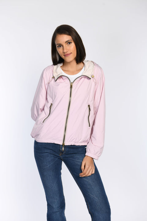 Model präsentiert die geschlossene Wendejacke in Rosa mit Seitentaschen und Zwei-Wege-Reißverschluss.