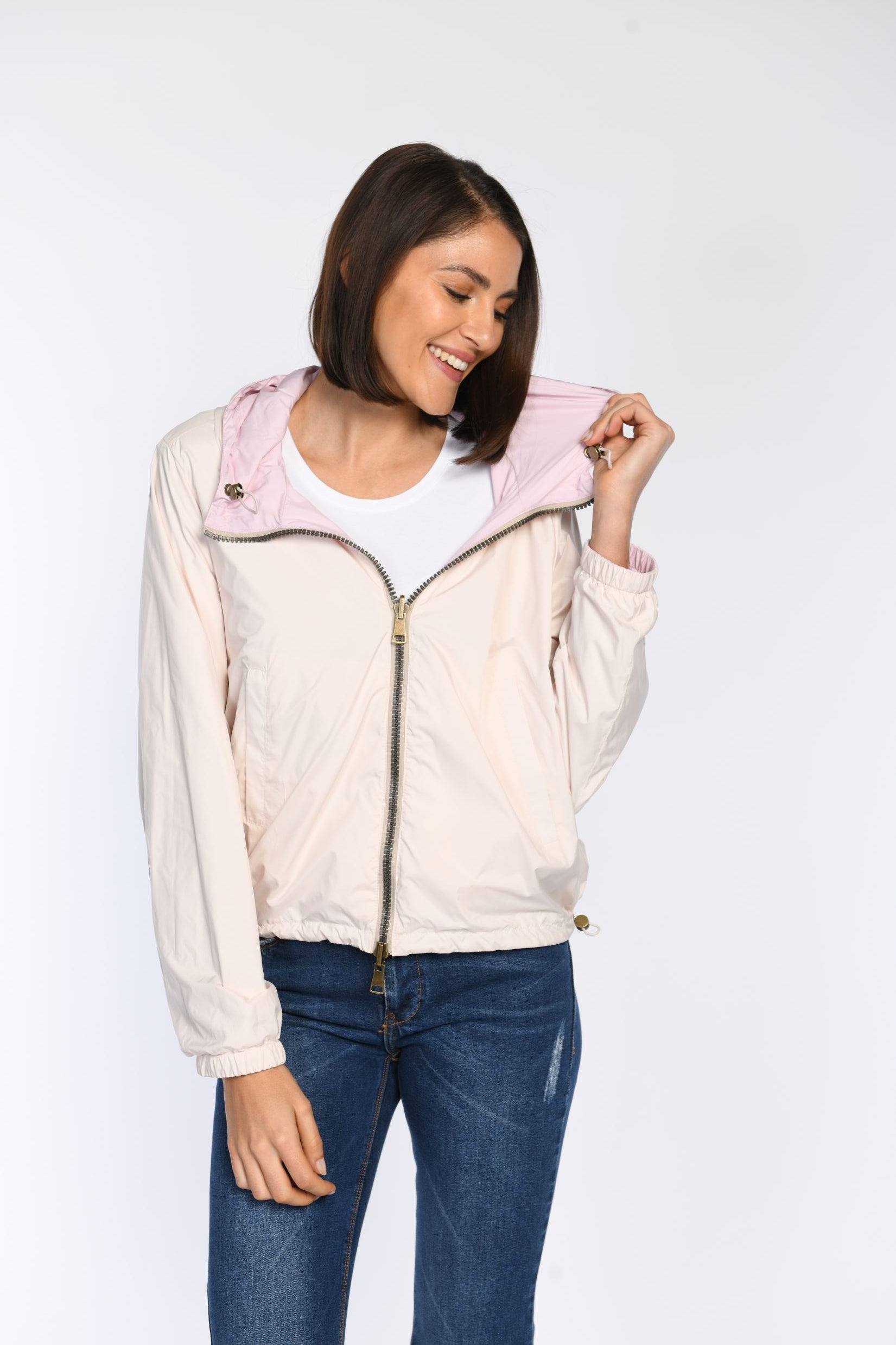 Model präsentiert geschlossene Wendejacke mit Fokus auf den Wendeeffekt: eine Seite rosa, die andere taupe.