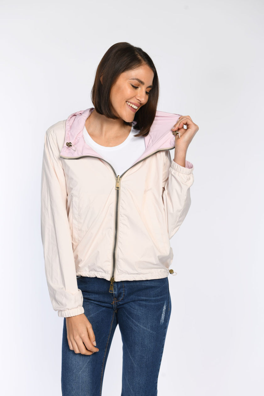 Model präsentiert geschlossene Wendejacke mit Fokus auf den Wendeeffekt: eine Seite rosa, die andere taupe.