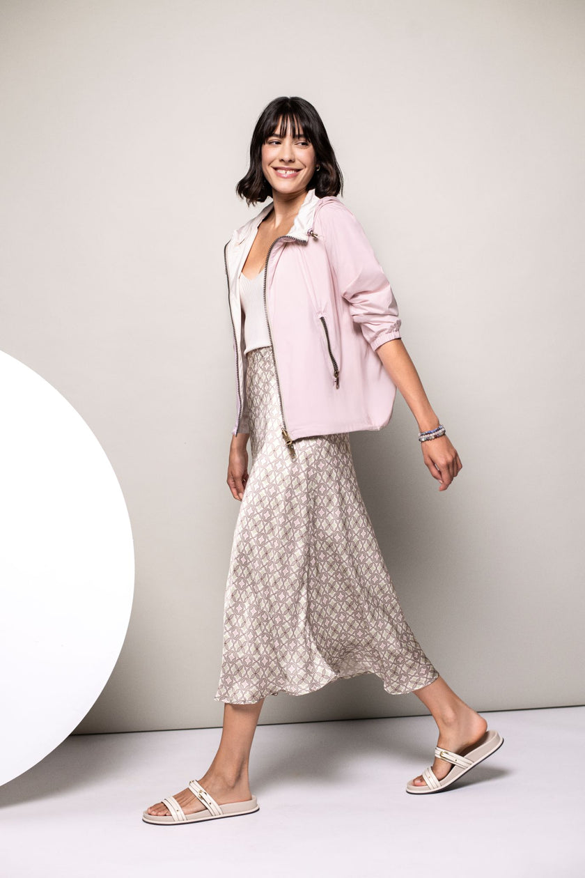 Model trägt offene Wendejacke in Rosa mit Reißverschlusstaschen.