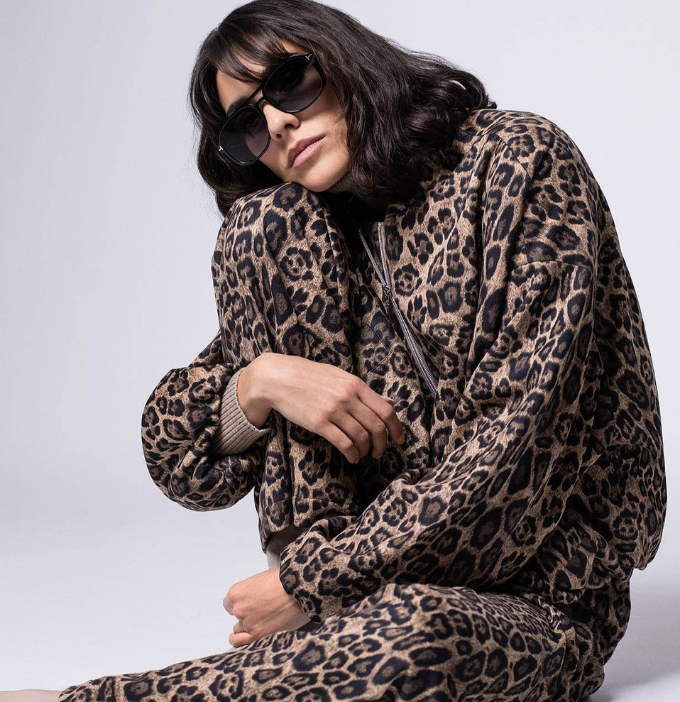 Zweiteiler im Leo-Print für Damen, bestehend aus lässigem Blouson und softer, weiter Hose – Model in lässiger Pose. -Shop the Look